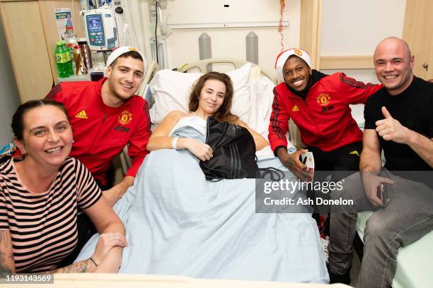 Diogo Dalot and Fred of Manchester United poses with Chloe during the club's annual Christmas hospital visits at Royal Manchester Children's Hospital...