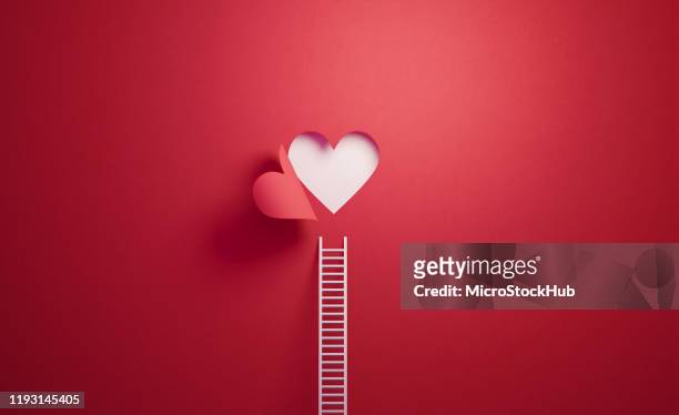 white ladder leaning on red wall with cut out heart shape - love stock pictures, royalty-free photos & images