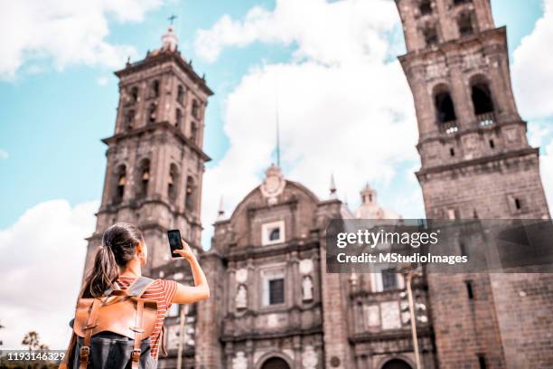 jonge vrouw die foto van cathedral basilica de puebla neemt - puebla mexico stockfoto's en -beelden