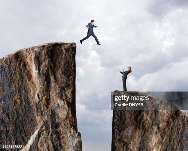 businessman jumps from one cliff to another - leap of faith stock pictures, royalty-free photos & images