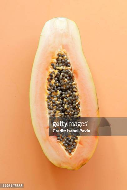 sliced papaya against orange background - albero di papaya foto e immagini stock