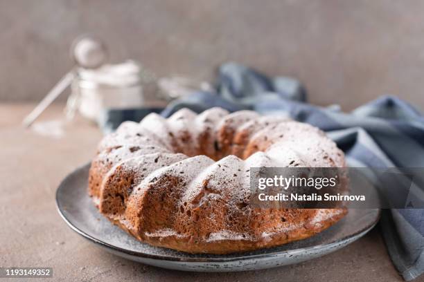 cupcake in the shape of a ring with raisins decorated with icing sugar on a light background. - paastaart stockfoto's en -beelden