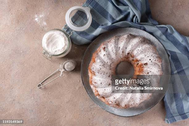 cupcake in the shape of a ring with raisins decorated with icing sugar on a light background. - tulbandcake stockfoto's en -beelden