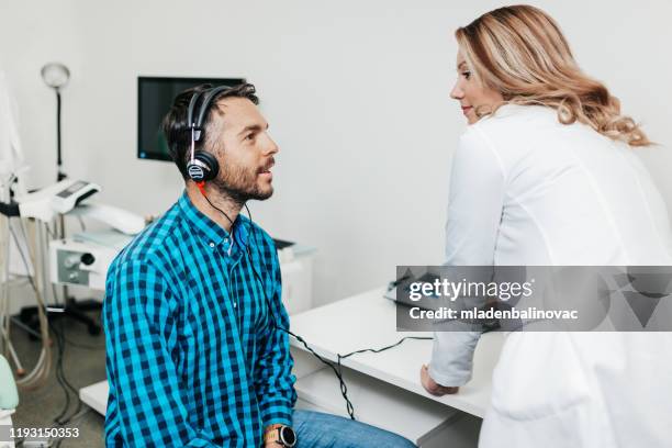 ärztliche höruntersuchung - audiologist stock-fotos und bilder