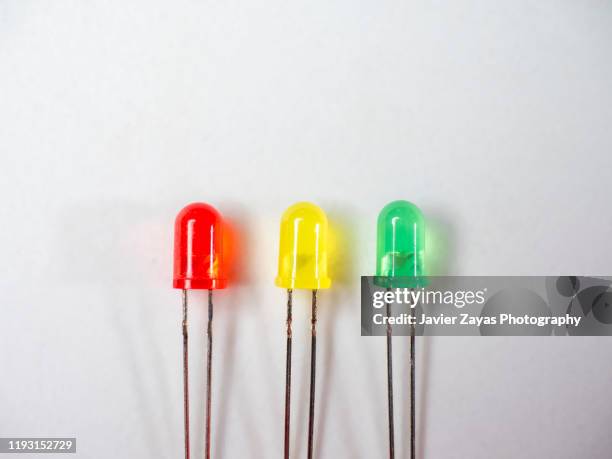 red, yellow and green led diodes on white background - luce led foto e immagini stock