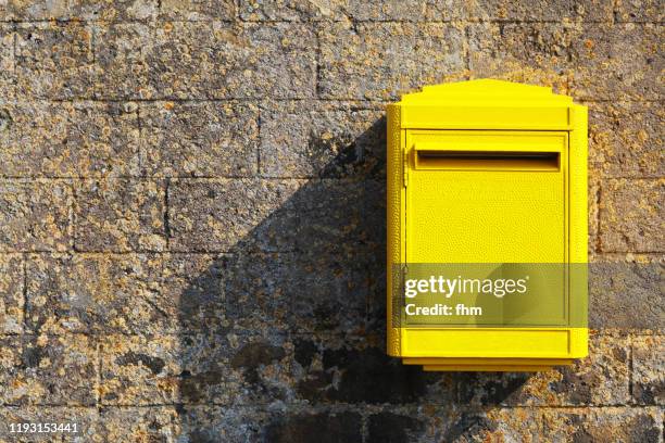 yellow postbox on a wall - courrier photos et images de collection