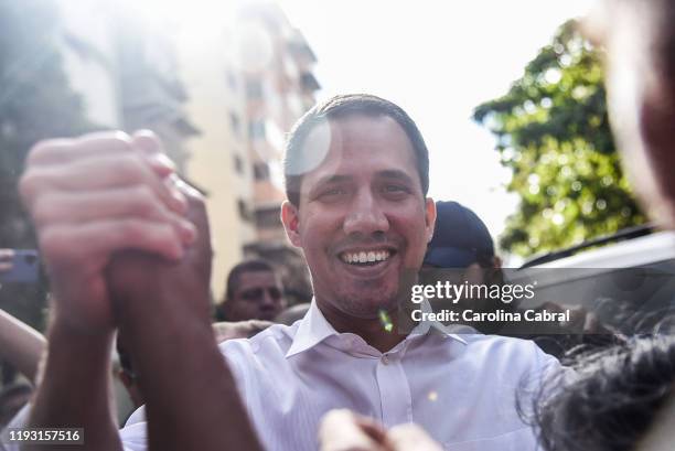 Opposition leader and reelected president of the National Assembly by anti-Maduro lawmakers majority Juan Guaido greets to supporters as he arrives...