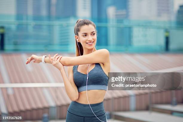 young girl is stretching after run and listening the music - leg stretch girl stock pictures, royalty-free photos & images