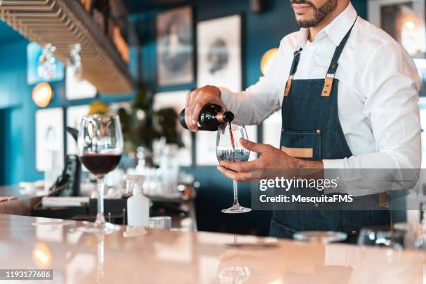 sommelier serviert rotwein in der luxus-hotelbar - wine tasting stock-fotos und bilder