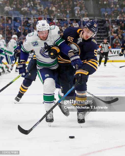 Rasmus Ristolainen of the Buffalo Sabres finishes his check on Tim Schaller of the Vancouver Canucks during the third period of play in the NHL...