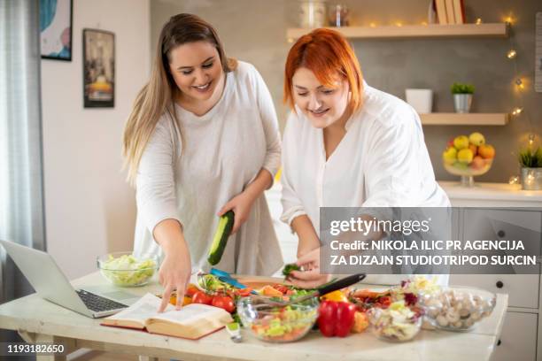 young smiling plus size women preparing salad. - healthy fats stock pictures, royalty-free photos & images