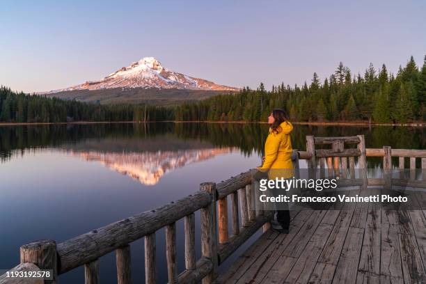 woman gazing at mt hood and trillium lake at sunset, government camp, or, us. - mount hood stockfoto's en -beelden