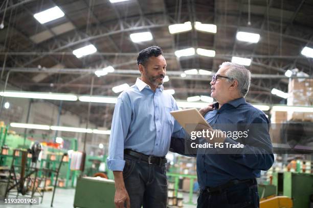 medewerkers plannen werken in een fabriek, met behulp van digitale tablet - factory owner stockfoto's en -beelden