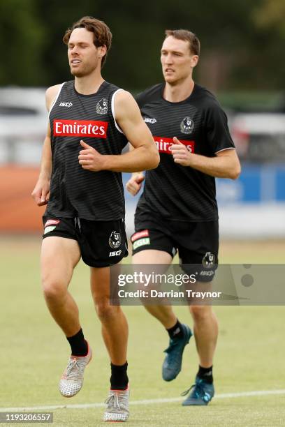 Matt Scharenberg and Jack Madgen warm up during a Collingwood Magpies AFL training session at The Holden Centre on December 11, 2019 in Melbourne,...