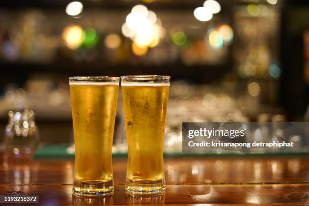 addictive substance,drinking,drinking,close-up of two men and women drinking together at the pub counter - gold bars stock-fotos und bilder