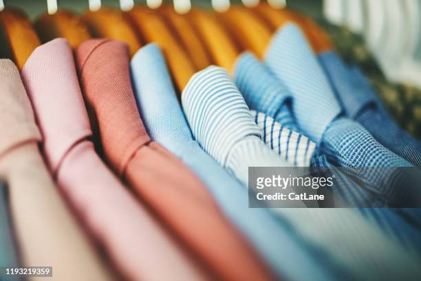 sortiment von herrenhemden auf holzkleiderbügeln - geschäftskleidung stock-fotos und bilder