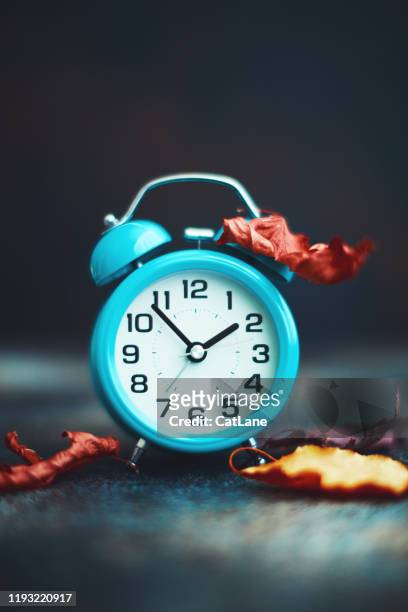 time for fall. teal alarm clock with leaves - daylight savings stock pictures, royalty-free photos & images