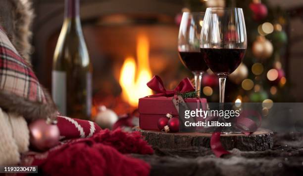 kerst rode wijn voor de open haard en kerstboom met geschenken - red wine stockfoto's en -beelden
