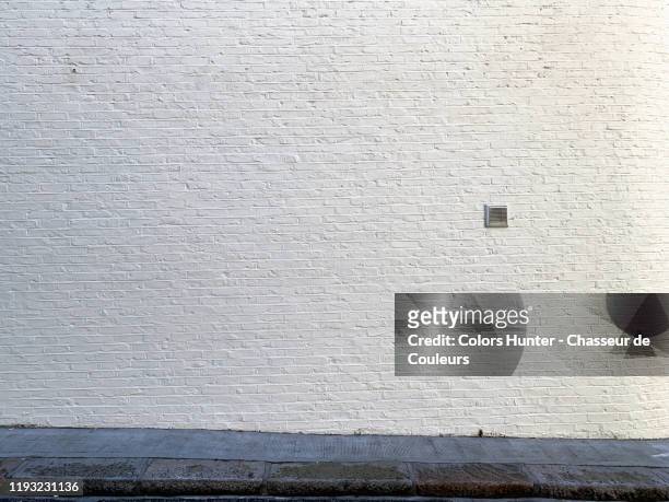 white brick wall with stone sidewalk in london - building walls stockfoto's en -beelden