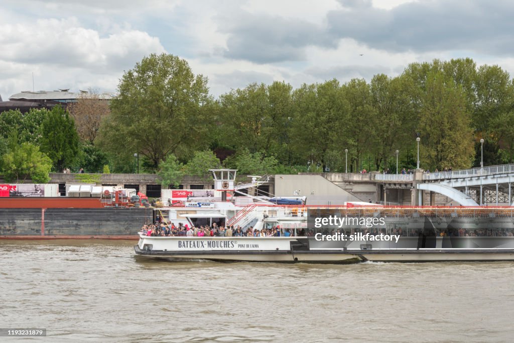 Day cruise ship on River Seine in Paris in France on cloudy day in spring