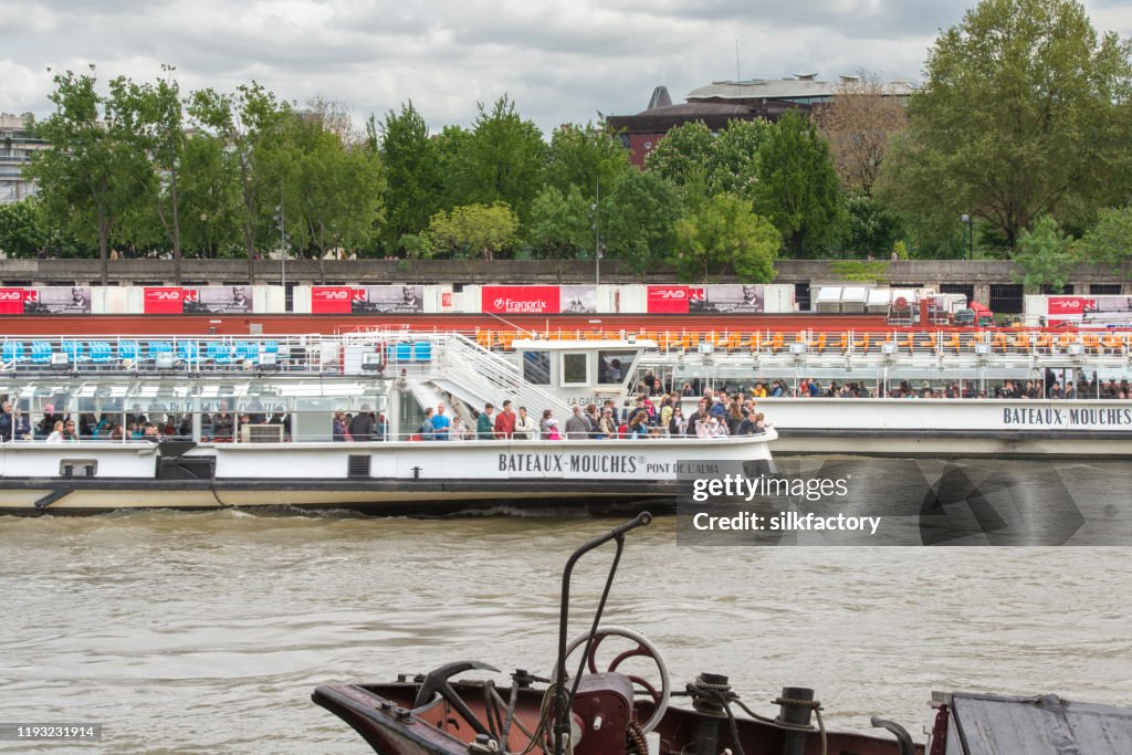 Day cruise ships on River Seine in Paris in France on cloudy day in spring