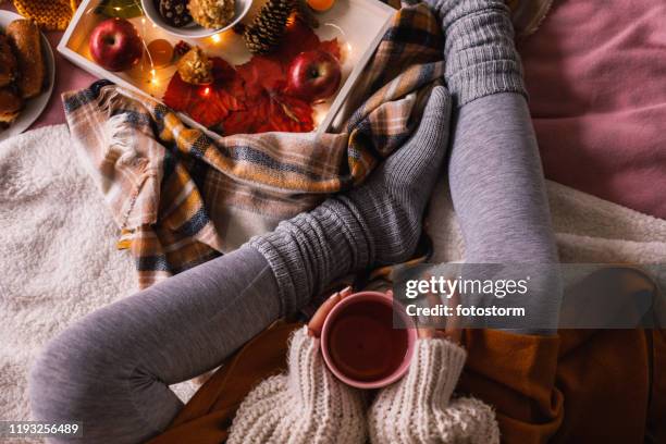 ondergedeelte van onherkenbaar vrouw genieten van een kopje thee - hygge stockfoto's en -beelden