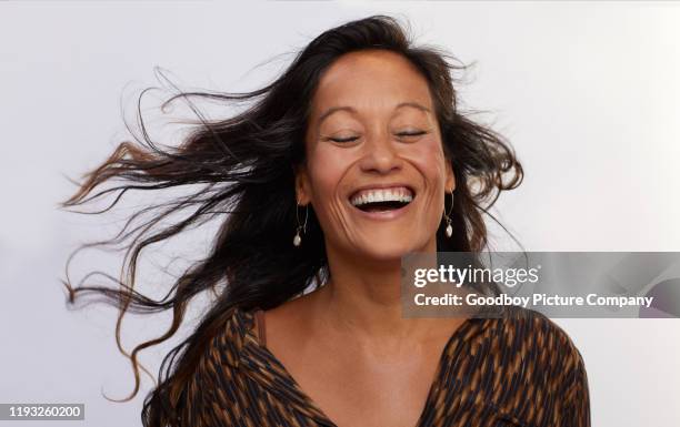 femme mûr avec le cheveu ébouriffé riant sur un fond gris - woman fresh air photos et images de collection
