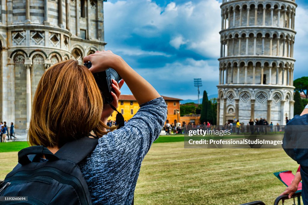 Een vrouw is het nemen van een foto van scheve toren van Pisa