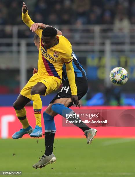 Moussa Wague of FC Barcelona jumps for the ball against Cristiano Biraghi of FC Internazionale during the UEFA Champions League group F match between...