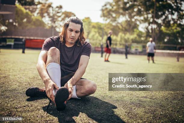 guy preparing for football match - sitting on floor stock pictures, royalty-free photos & images