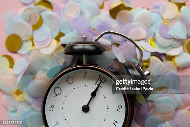 vintage alarm clock at 12 o'clock, with confetti. new year's eve concept - 12 o'clock - fotografias e filmes do acervo