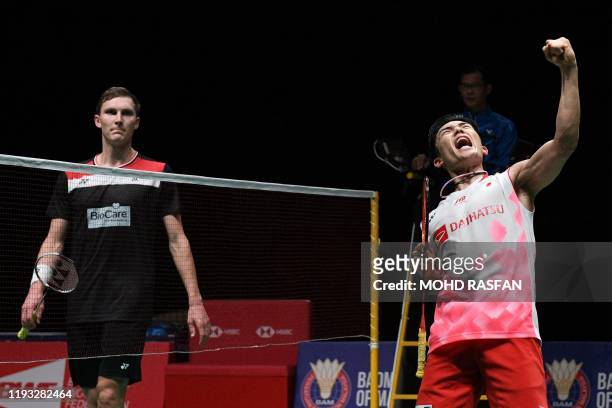 Japan's Kento Momota reacts after winning against Denmark's Viktor Axelsen during their men's singles final match at the Malaysia Open badminton...
