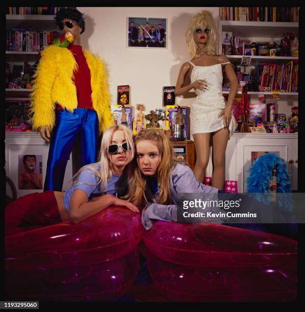 British pop duo Carrie Askew and Jacqui Blake of Shampoo lying on two inflatable chairs, Japan, 1994. The room of the photo shoot includes oddities...