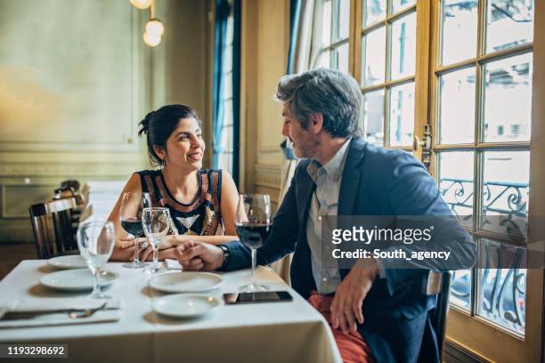 mature couple on a date in restaurant - couple dinner date stock pictures, royalty-free photos & images