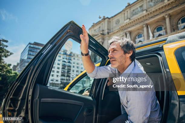 mature man getting out of the cab - disembarking stock pictures, royalty-free photos & images