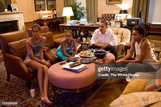 In this handout provided by the White House, U.S. President Barack Obama and first lady Michelle Obama with their daughters Sasha and Malia watch the...