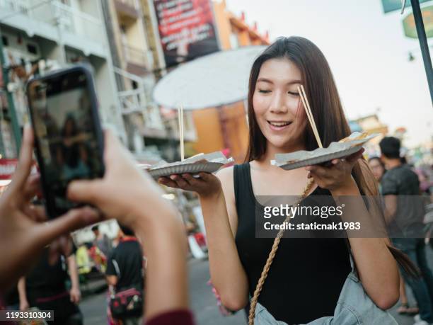 des amis asiatiques prennent une photo de la nourriture de rue de thaïlande à khao san road. - plate food photos et images de collection