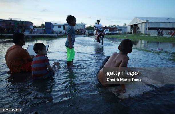 Boys play in floodwaters occurring around high tide in a low lying area near the airport on November 27, 2019 in Funafuti, Tuvalu. Sea water...