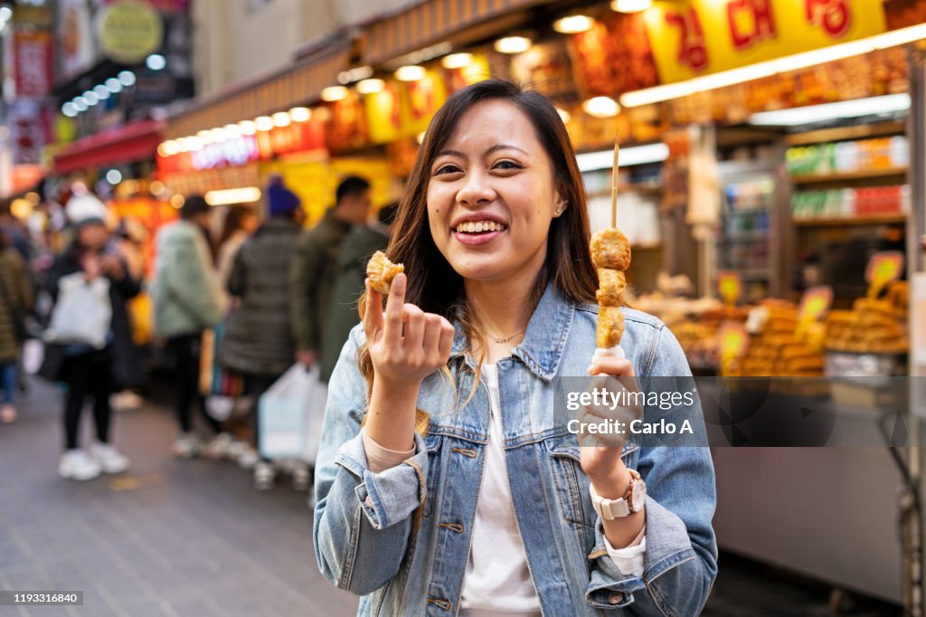 Woman eating street food at market