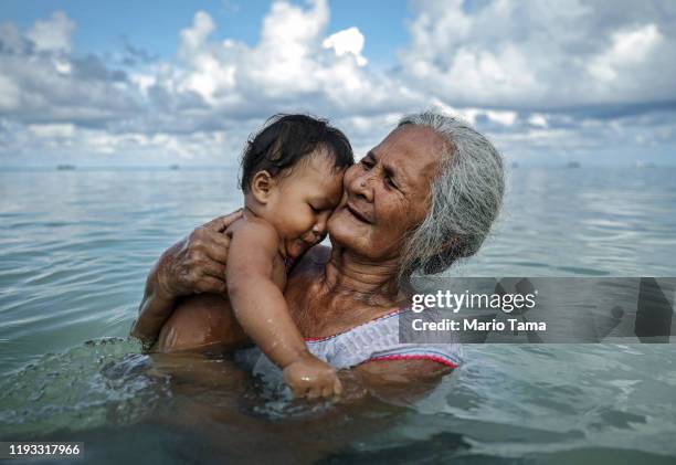 Suega Apelu bathes a child in the lagoon on November 28, 2019 in Funafuti, Tuvalu. The low-lying South Pacific island nation of about 11,000 people...