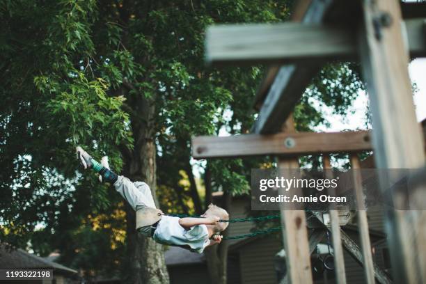 boy swings on a backyard swing set - backyard swing set stock pictures, royalty-free photos & images