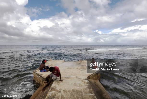 People gather on a pier on December 06, 2019 in Tanna, Vanuatu. Satellite data show sea level has risen about 6mm per year around Vanuatu since 1993,...