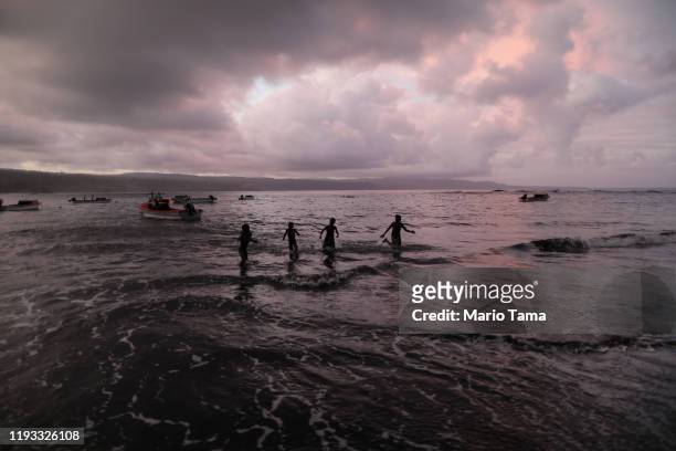 Young villagers play in the Pacific Ocean in the village of Waisisi on December 04, 2019 in Tanna, Vanuatu. All of the homes in Waisisi were...