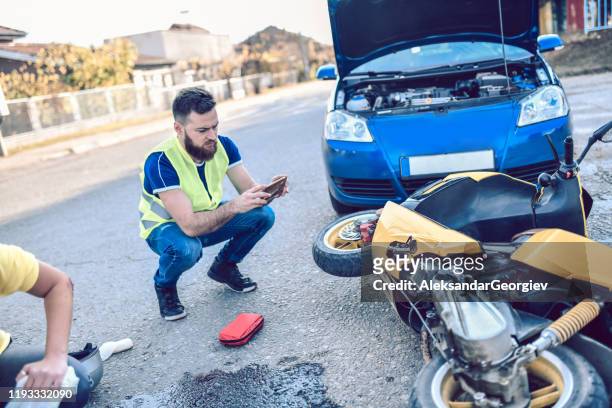 male photographing damage in traffic accident - motorcycle crash stock pictures, royalty-free photos & images