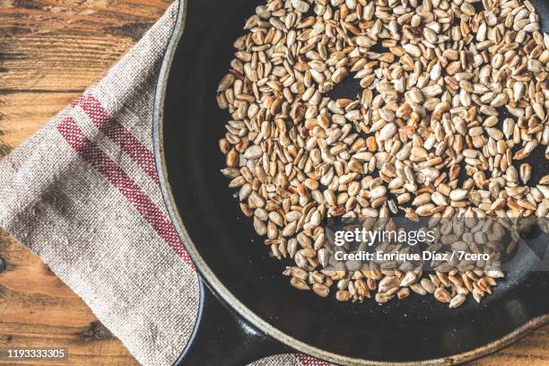 toasted sunflower seeds in a skillet (1) - sonnenblumenkerne stock-fotos und bilder