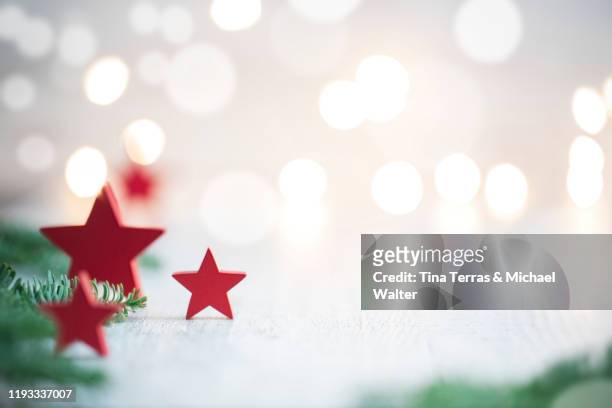 christmas background with red stars and red christmas balls with fairy lights. - christmas background green stock-fotos und bilder