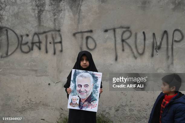 Shiite Muslim girl holds a poster of Iranian commander Qasem Soleimani as she takes part in a anti-US protest against the killing of top Iranian...