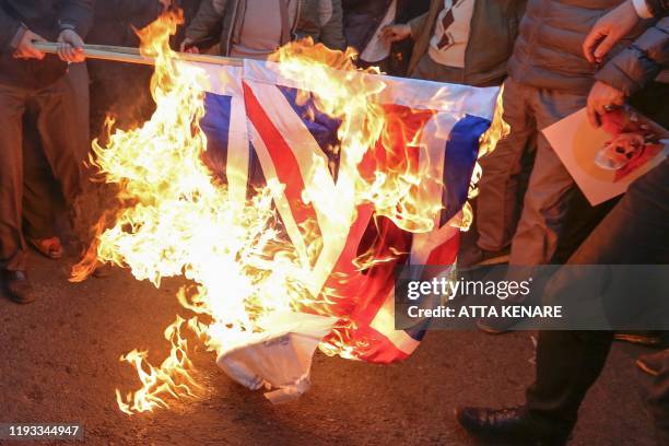 Iranian demonstrators set alight a Union Jack in front of the British embassy in Iran's capital Tehran on January 12, 2020 following the British...