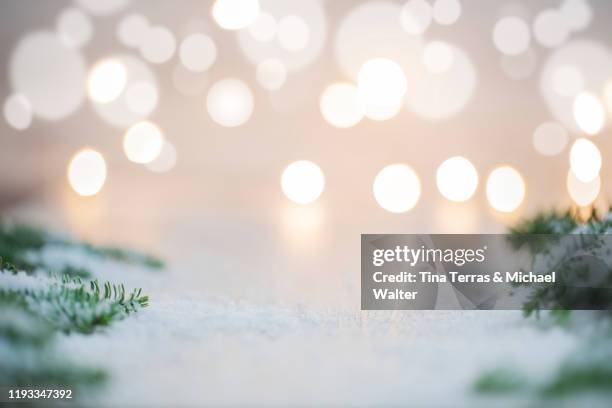 background in christmas mood. bokeh and fairy lights in the background. fir branches and snow. copy space. - decoración navideña fotografías e imágenes de stock