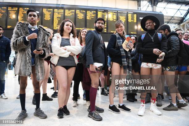 People pose as they take part in the annual 'No Trousers On The Tube Day' at Waterloo Station in central London on January 12, 2020. - Starting in...